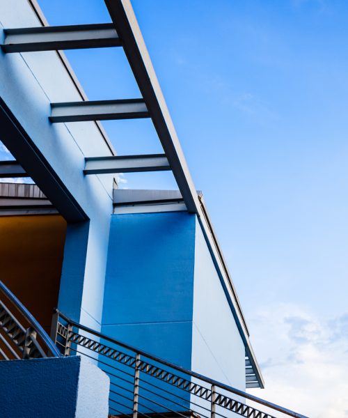 Staircase and terrace of a building with blue and orange walls,